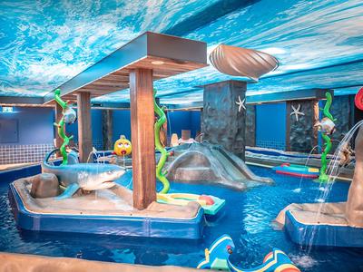 Innenpool mit Wasserspielplatz und rutschigen Attraktionen in einem Hotel