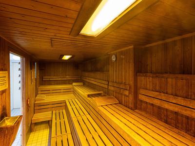 Wnętrze sauny fińskiej z drewnianymi panelami i ławkami do siedzenia.