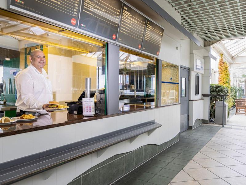 Szef kuchni w hotelu przy nowoczesnym stanowisku z winem i świeżym jedzeniem.