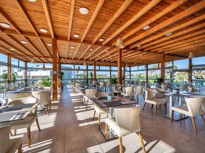 Helles, modernes Restaurant mit Holzdach, großen Fenstern und schön gedeckten Tischen.