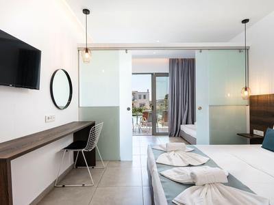 Modernes Hotelzimmer mit Doppelbett, Schreibtisch, Fernseher und Balkon mit Blick.