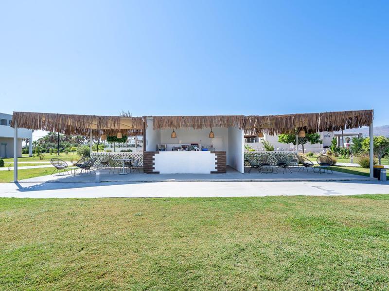 Open lounge with roof and swings in a sunny hotel garden