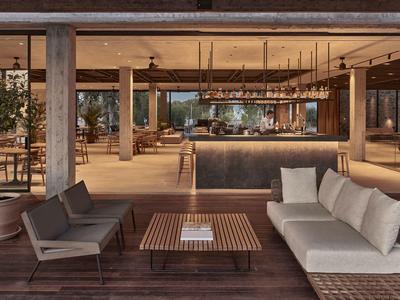 Moderner Lounge-Bereich mit Sesseln, Sofa, Holztisch und indirekter Beleuchtung in warmen Tönen.