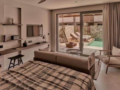 Modernes Schlafzimmer mit Doppelbett, Couch, Flachbildschirm, Holzregalen und Terrasse mit Pool.