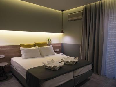 Moderně zařízený hotelový pokoj s velkou postelí, nočními stolky a tlumeným osvětlením.