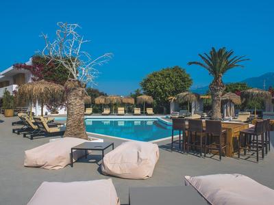 Lehátka a bazén s stoly pod modrou oblohou