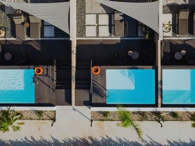 Tři moderní vily vedle sebe s privátními bazény a lehátky.