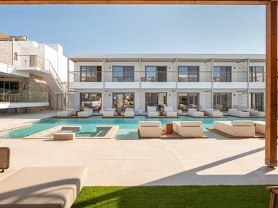 Moderner Hotelpool mit Liegestühlen und Lounges in sonnigem Innenhof