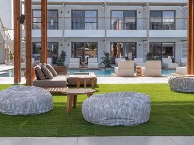 Nowoczesny taras hotelowy z workami sako, sofą i basenem przed wielopiętrowym budynkiem