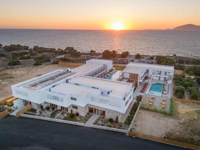 Nowoczesny hotel z basenem i widokiem na morze o zachodzie słońca.