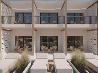 Moderne Unterkunft mit zwei Etagen, Balkon und Pool unter klarem Himmel.