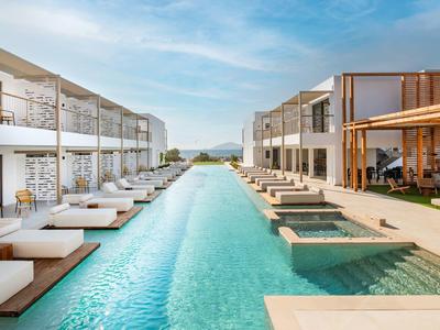 Nowoczesny hotel z długim basenem i leżakami pod niebieskim niebem