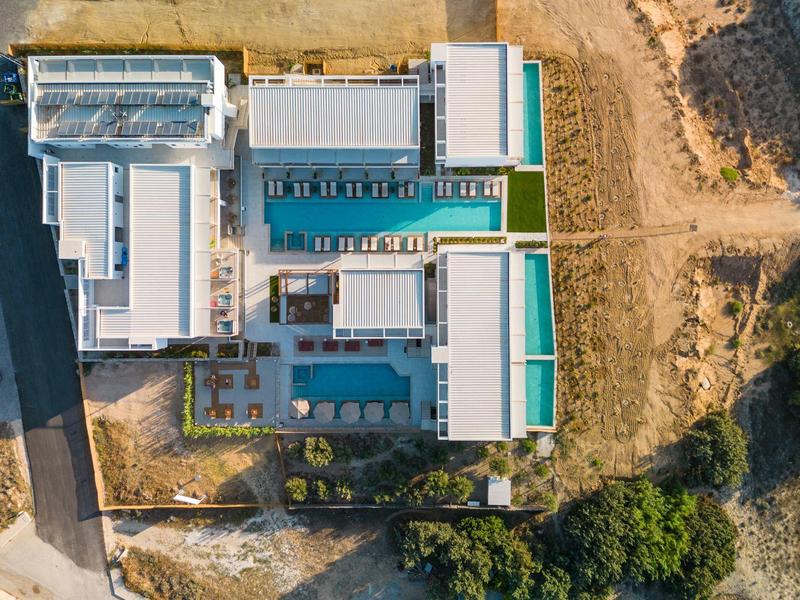 Widok z lotu ptaka na nowoczesny hotel z kilkoma basenami i suchym terenem wokół.