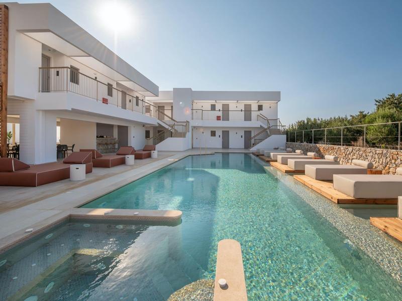 Nowoczesny basen na zewnątrz z tarasem słonecznym i leżakami pod czystym niebem.