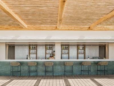 Moderner Hotelbarbereich mit grünem Marmor und Bambusdeckengestaltung.