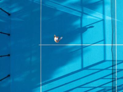 Eine Person schwimmt in einem klaren, blauen beheizten Hotelpool von oben betrachtet.