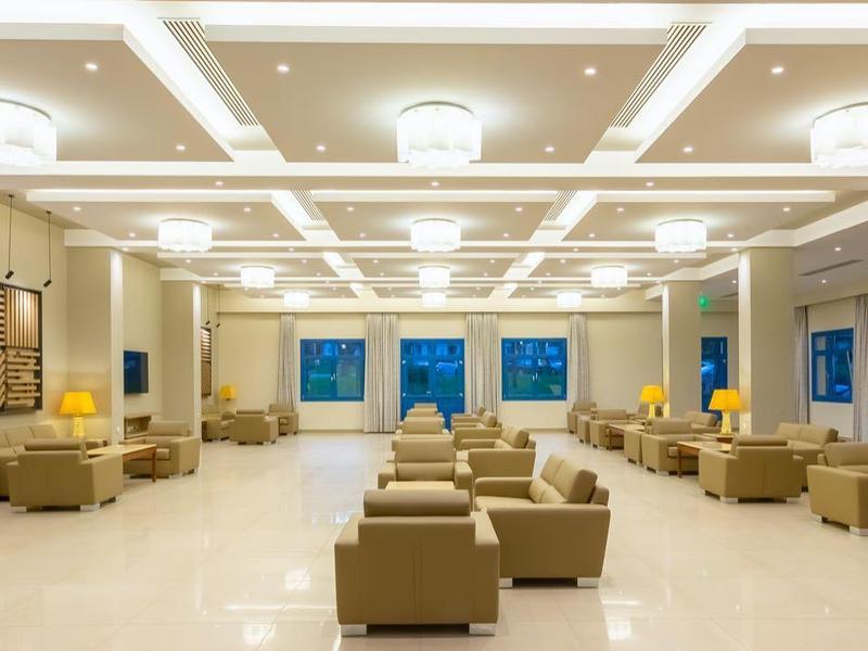 Světlá moderní hotelová lobby s posezením a velkými okny.