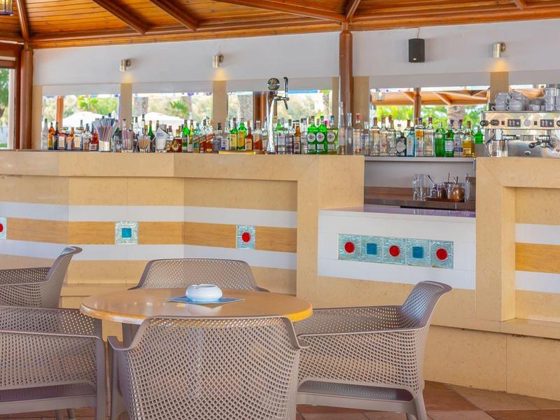 Pohodlná část sezení s kulatými stoly a židlemi v kryté hotelové restauraci.