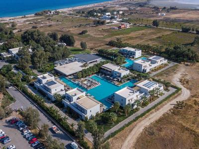 Luftaufnahme eines Hotels mit mehreren Pools und Meerblick in einer ländlichen Umgebung.