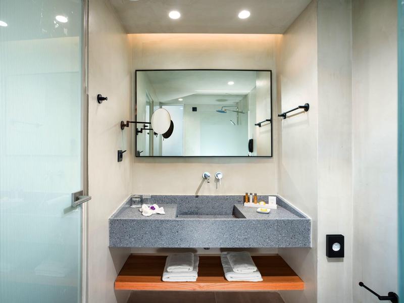 Moderne hotelbadkamer met dubbele wastafels, grote spiegel en minimalistisch ontwerp.