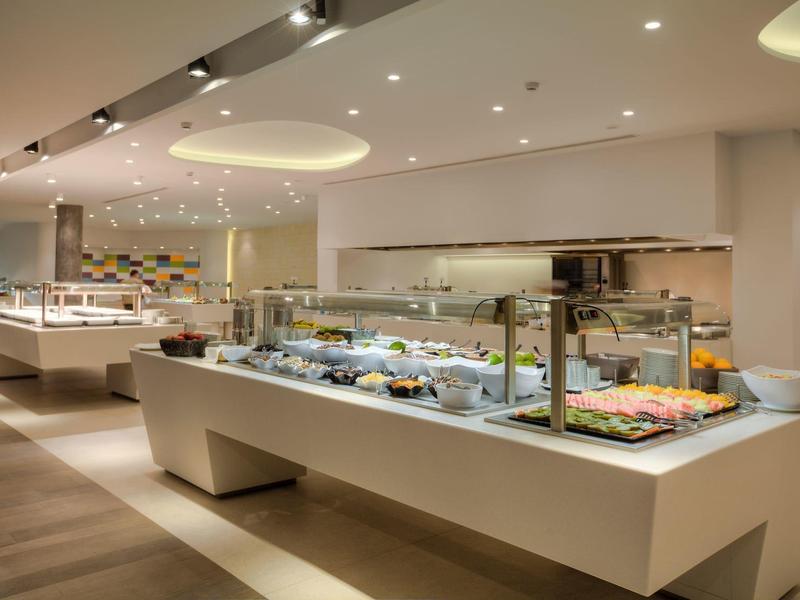 Modern hotelbuffet met goed verlichte voedselpresentaties en een schoon, ruim ontwerp.