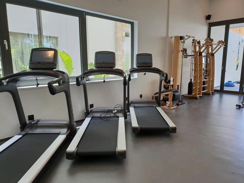 Moderne sportschool met drie loopbanden en natuurlijk licht door grote ramen