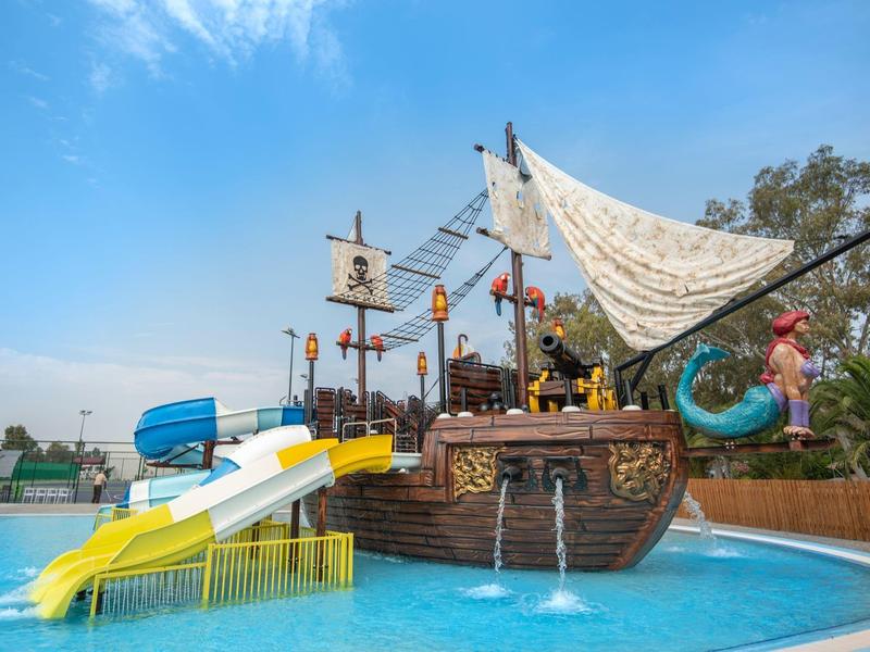 Waterpark met een speelgedeelte in de vorm van een piratenschip met glijbanen en fonteinen.