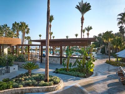 Leisure area with pools, pathways, and palm trees in tropical resort.