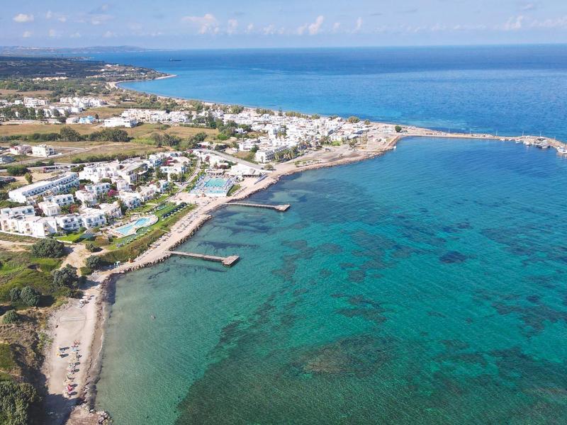 Küste einer Stadt mit klarem blauem Wasser und weiß getünchten Gebäuden unter blauem Himmel