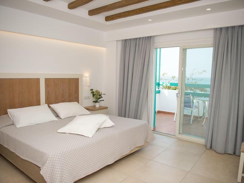 Modernes Hotelzimmer mit Doppelbett und Balkon mit Meerblick