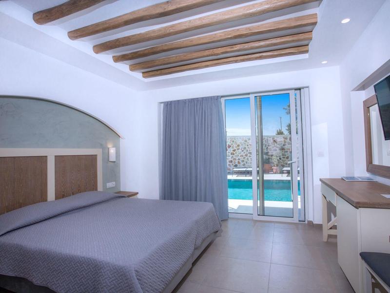 Modernes Hotelzimmer mit Doppelbett, Holzbalkendecke und Zugang zu Balkon mit Poolblick.