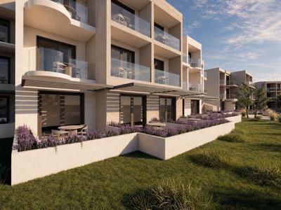 Moderner Hotelkomplex mit Terrassen, Liegestühlen und gepflegtem Garten bei Sonnenuntergang.