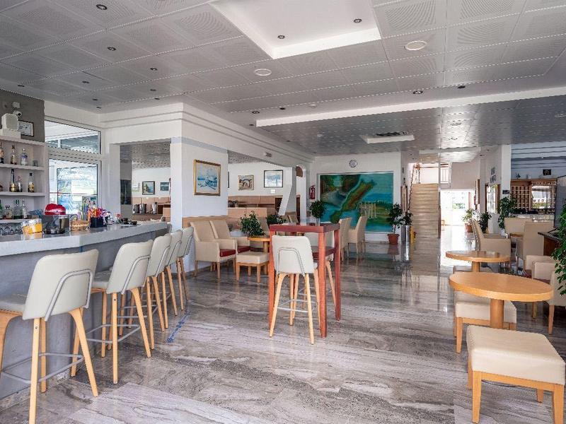 Jasny, nowoczesny bar hotelowy z szarymi stołkami barowymi, drewnianymi stołami i roślinami