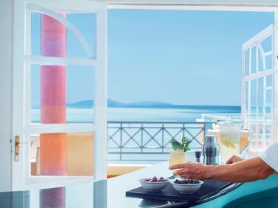 Mesa bien iluminada junto a la ventana con vista al mar y una terraza.