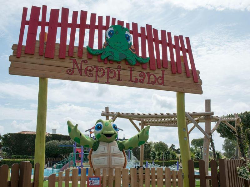 Barevný vstup do Happi Land s dekoracemi zvířat a dřevěným plotem.