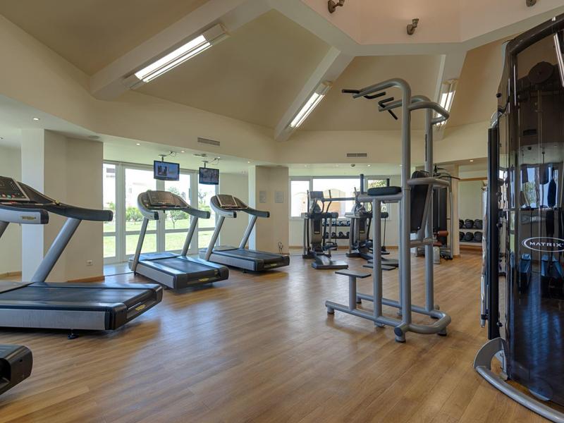 Prostorná posilovna s běžeckými pásy a moderním vybavením na dřevěné podlaze.