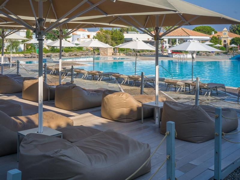 Lehátka a slunečníky kolem venkovního bazénu v hotelu.