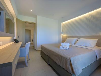 Modernes Hotelzimmer mit Doppelbett, Schreibtisch und indirekter Beleuchtung an der Wand.