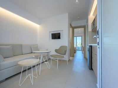 Moderner, heller Hotellounge-Bereich mit Sofa, Sesseln und Flachbildfernseher.