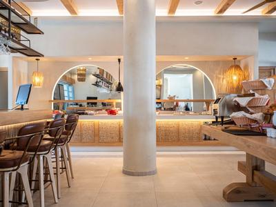 Moderner Hotelbarbereich mit Holzmöbeln, bequemen Sitzgelegenheiten und warmem Ambiente.