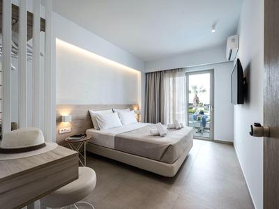 Modernes Hotelzimmer mit Doppelbett, Schreibtisch, Balkon und neutralen Farben.