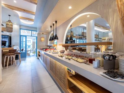 Modernes Frühstücksbuffet in einem hellen, stilvollen Hotelrestaurant mit Holzakzenten.