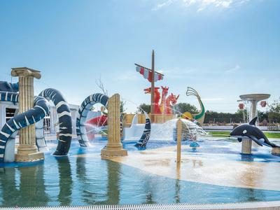 Colorful water park with slides, columns, and animal figures under a blue sky.
