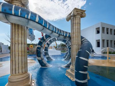 Wasserrutsche mit Säulendekor und Spirale in einem Außenpoolbereich bei schönem Wetter.