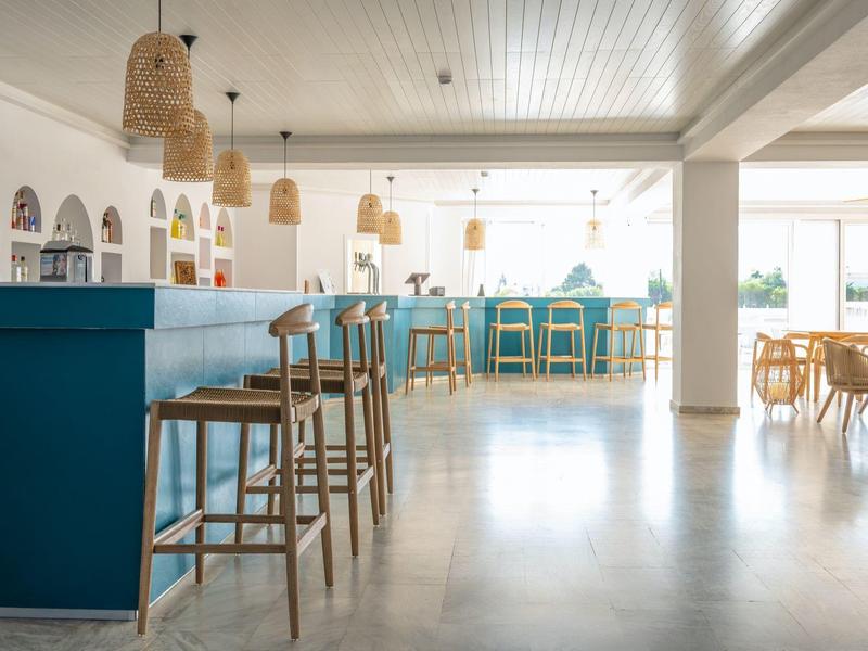 Bright modern café with blue counters and wooden stools in an open space.