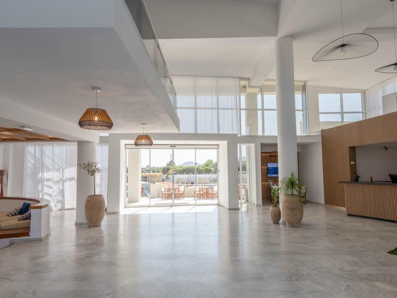 Bright, modern hotel lobby area with large windows and light tiled flooring.