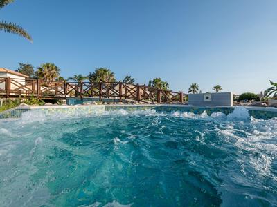 Blauw bubbelbad met bruisend water op een hotelterras onder een heldere hemel.