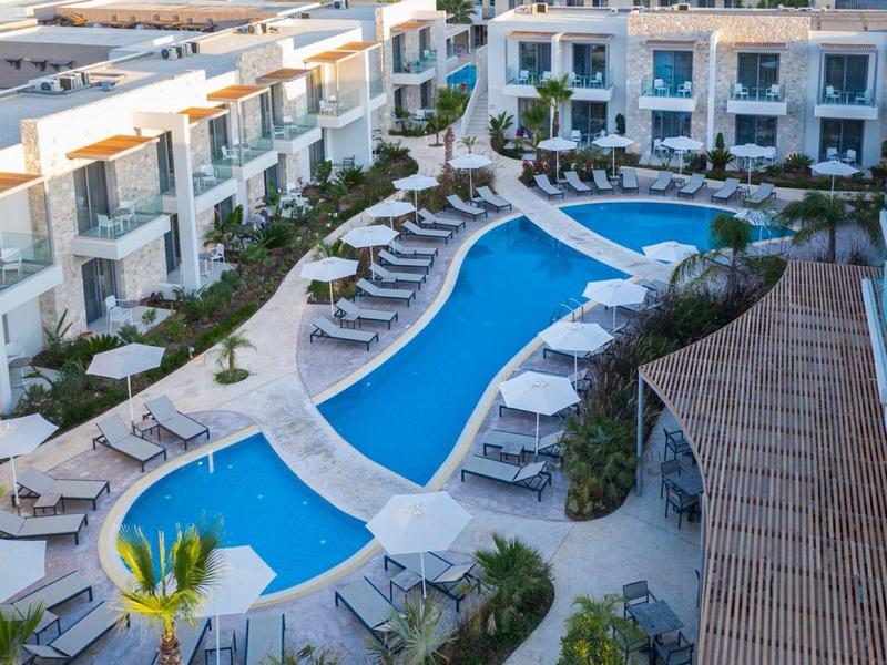 Hotel z zaokrąglonym basenem, leżakami i nowoczesnymi pokojami w kształcie litery U