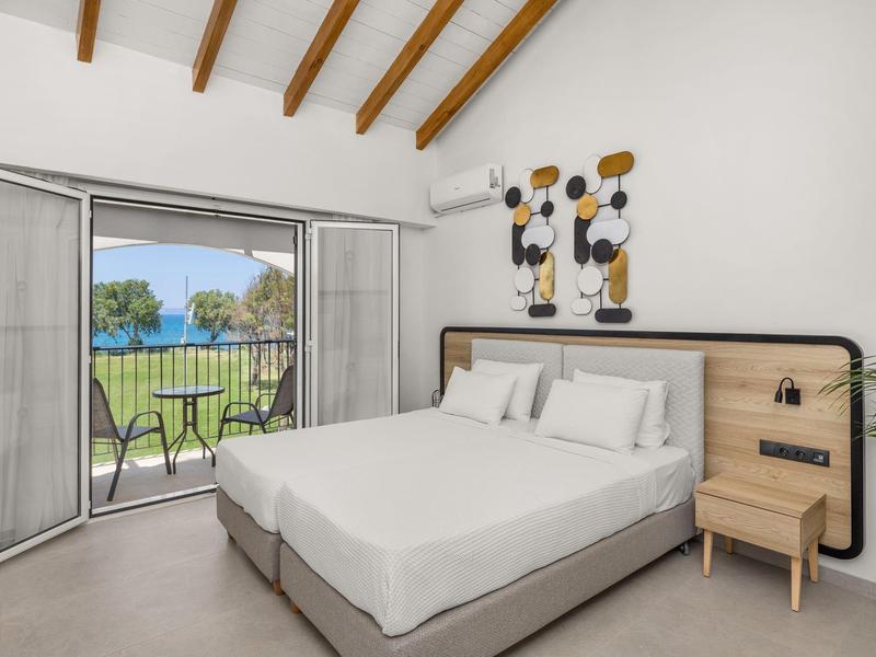 Camera moderna con letto grande e porte scorrevoli che si aprono su un giardino con vista piscina.