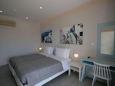 Modernes Hotelzimmer mit Doppelbett, Nachttischen, Stuhl und Wanddekoration.